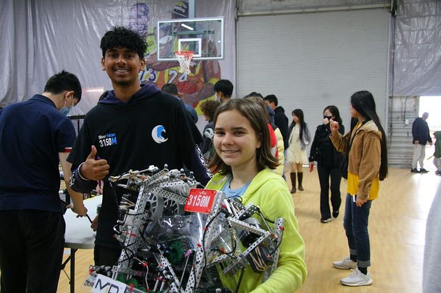 Two of our members holding a robot at a comp